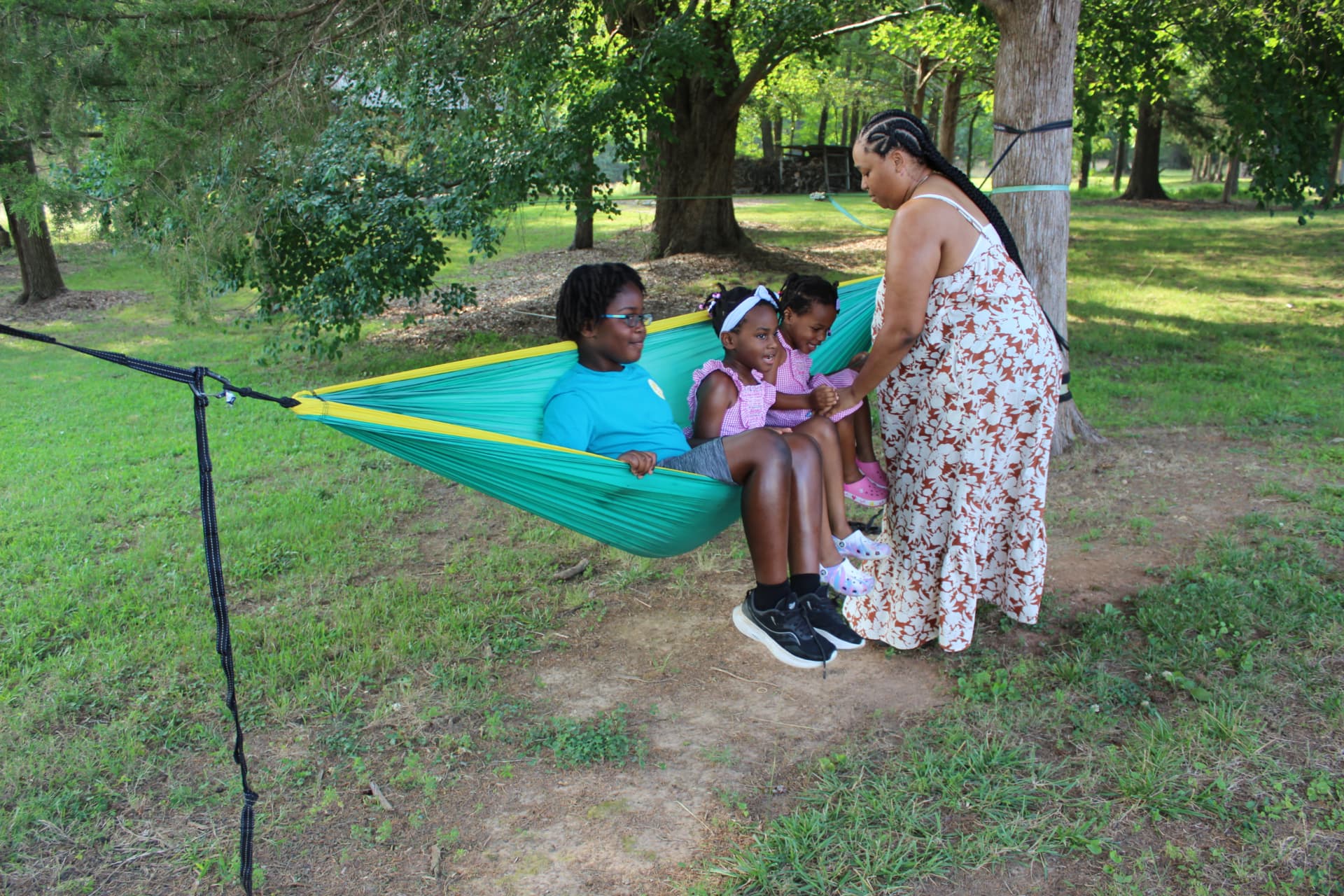Families and children resting together in a hammock at a community gathering