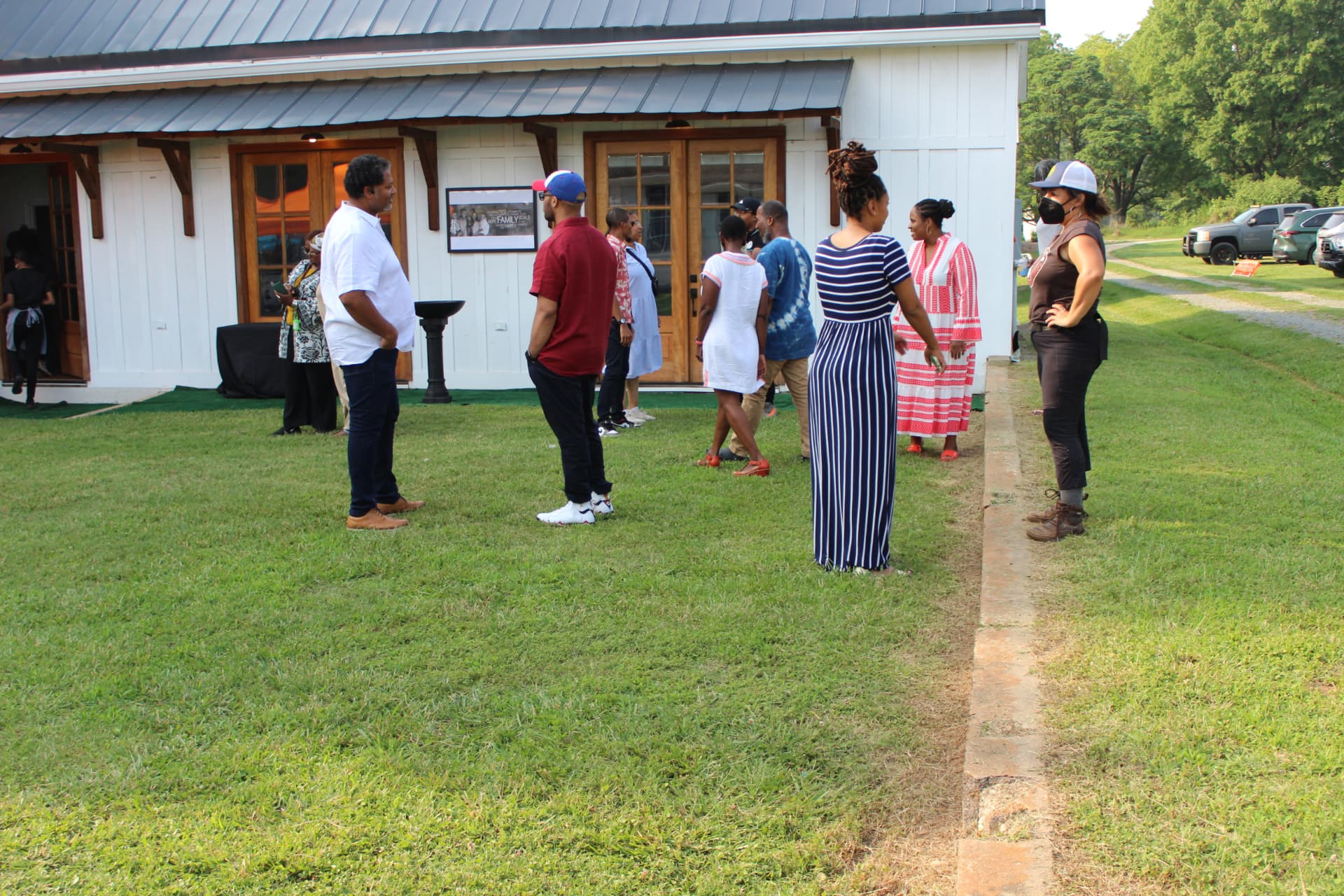 Neighbors gathered outside a house on a grassy lot in East Durham