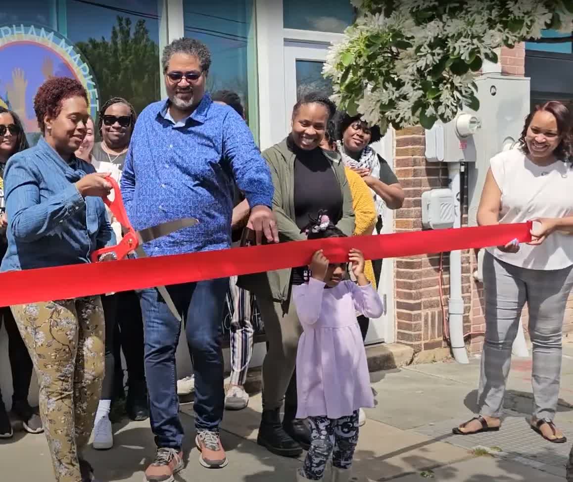 Neighbors cutting the ribbon at the East Durham Market