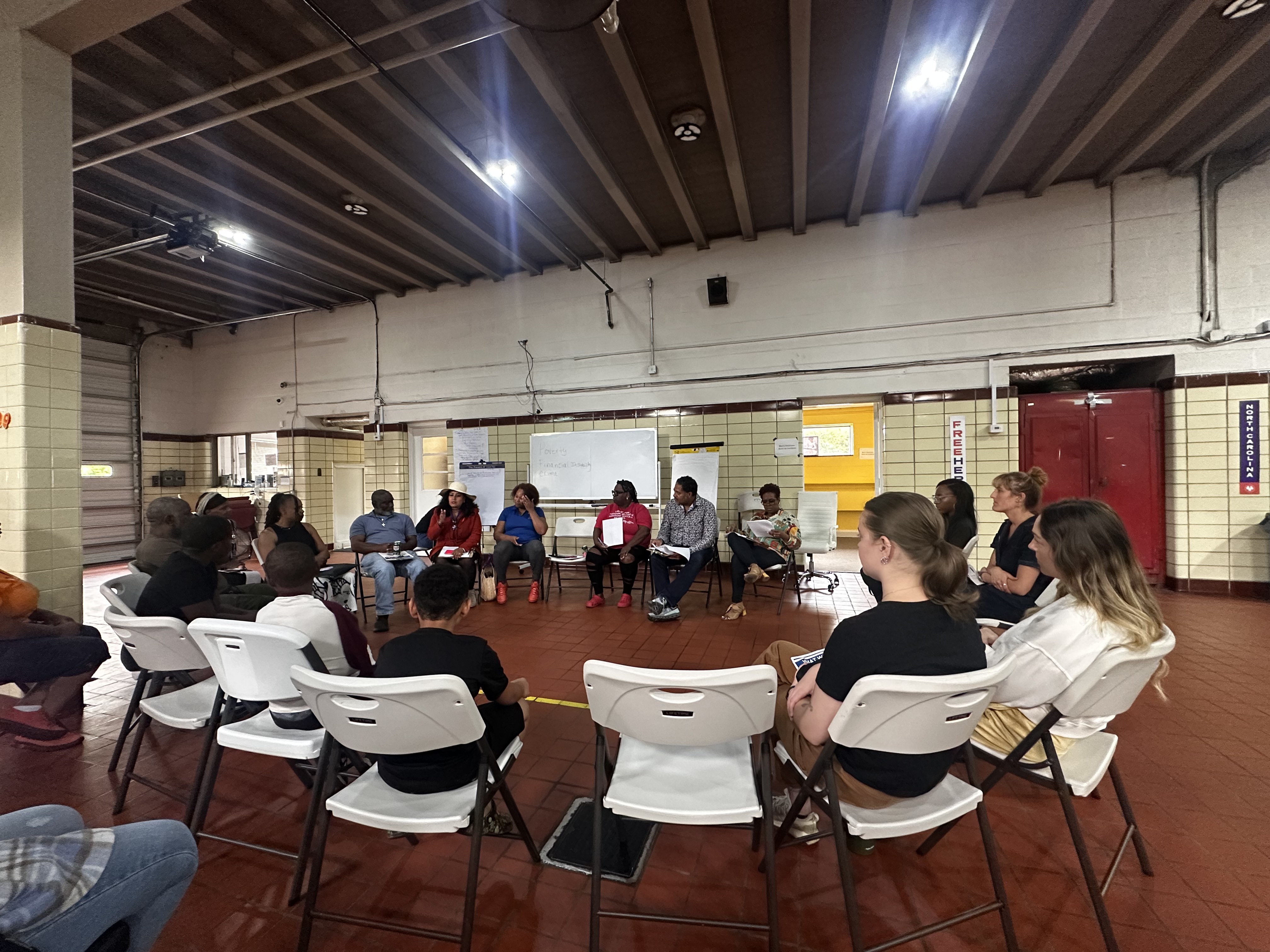 Neighbors seated in a large circle during a community listening session