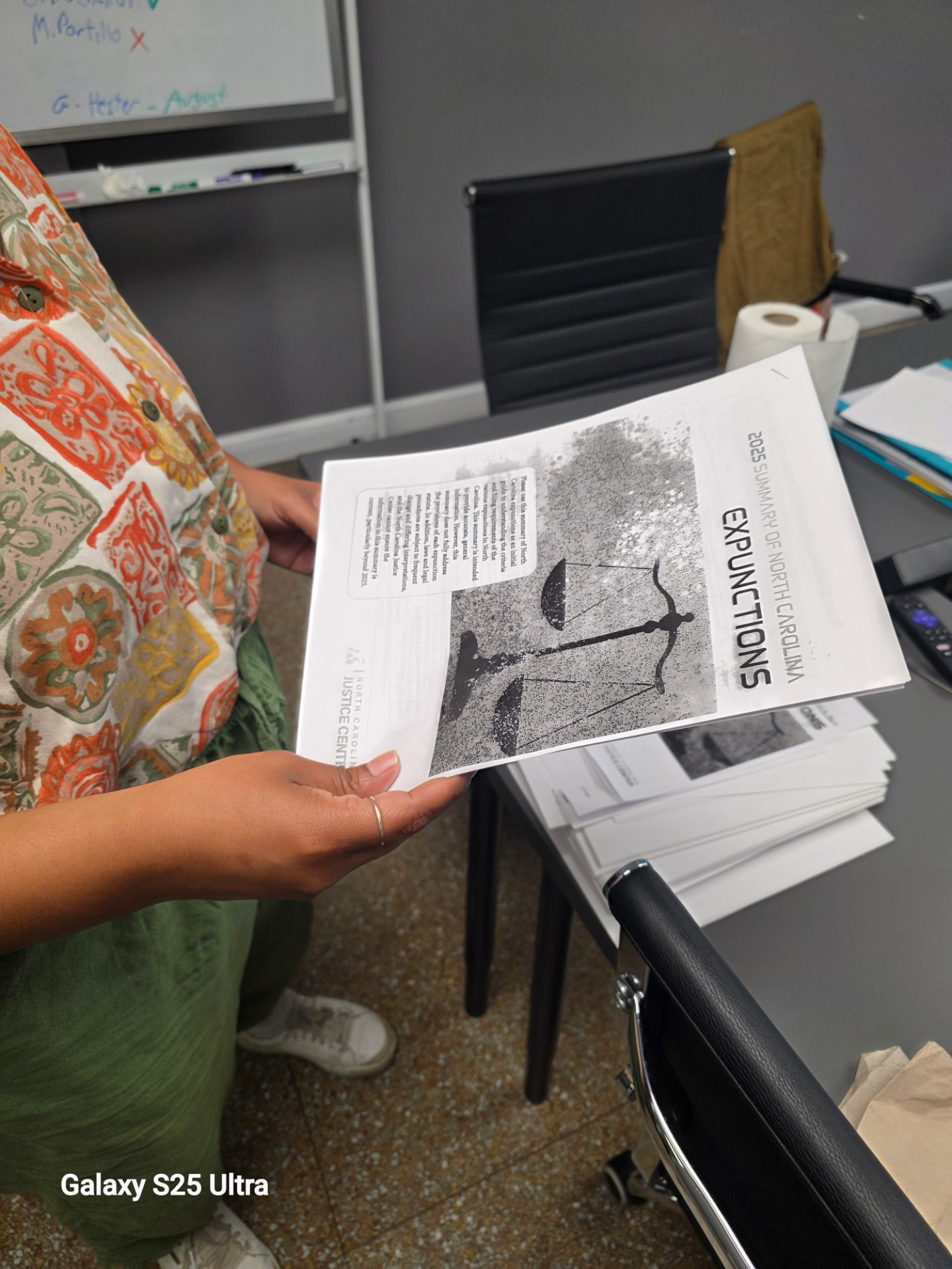 A neighbor holding the 2025 Summary of North Carolina Expunctions from the NC Justice Center